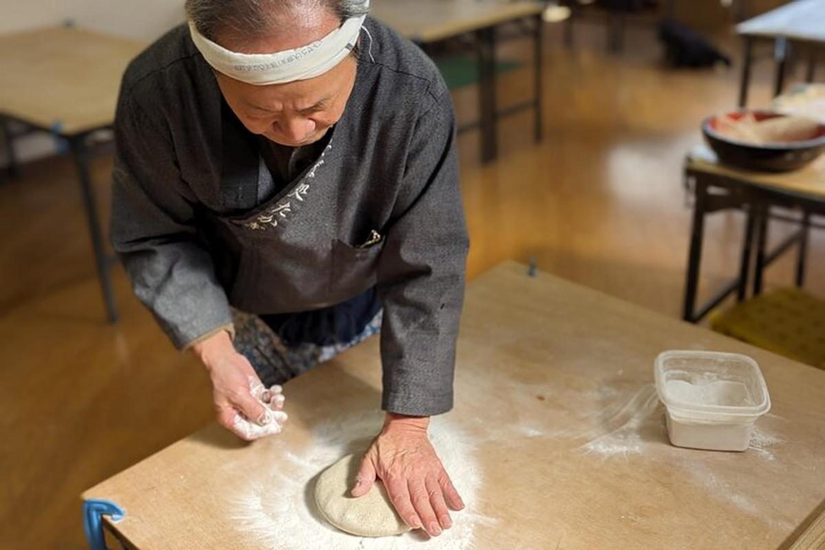 a man is making a pizza on a table