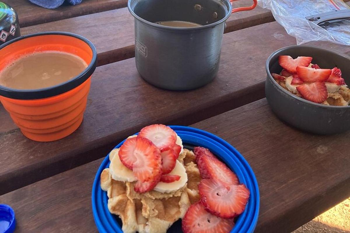 Blár diskur af vöfflum með jarðarberjum og bolla af kaffi
