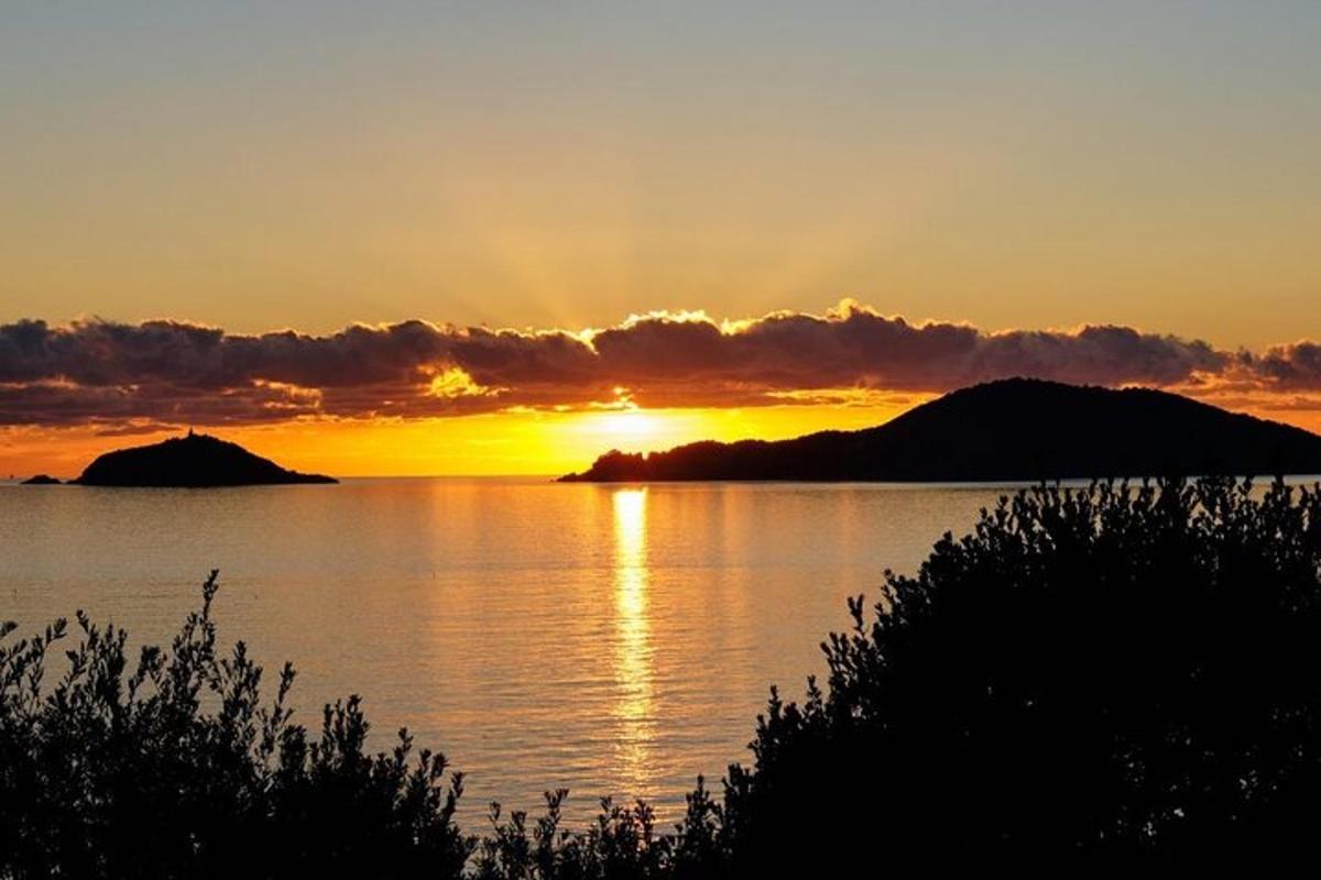 un tramonto su uno specchio d'acqua con montagne