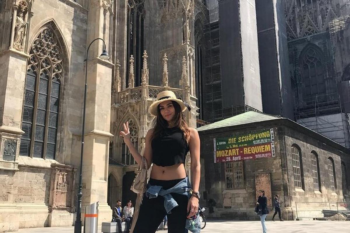 žena v klobouku stojící před budovou
