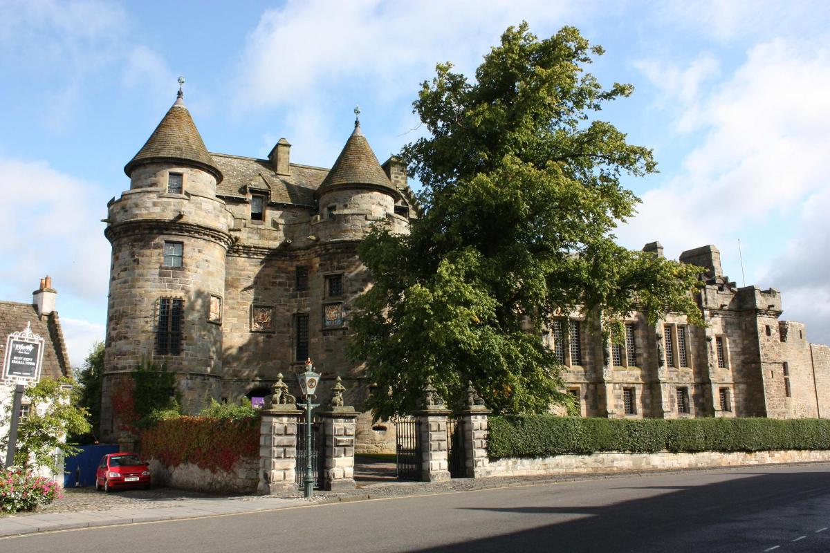 et gammelt slott med et tre foran seg
