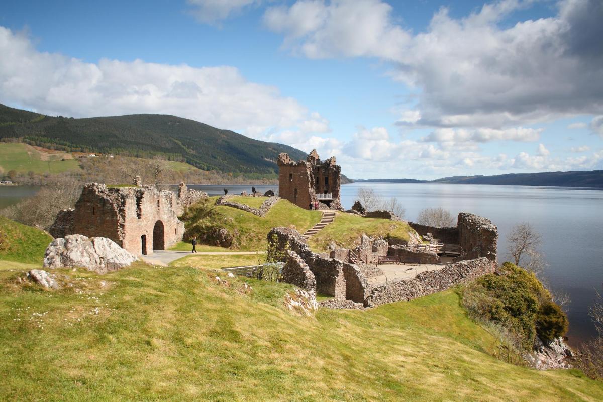 a castle on a hill next to a body of water