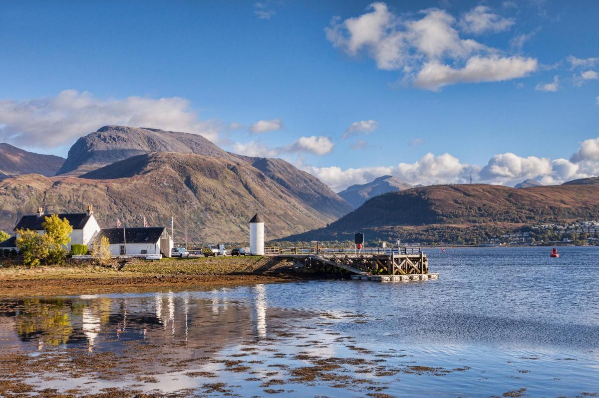a dock on a body of water with mountains in the background