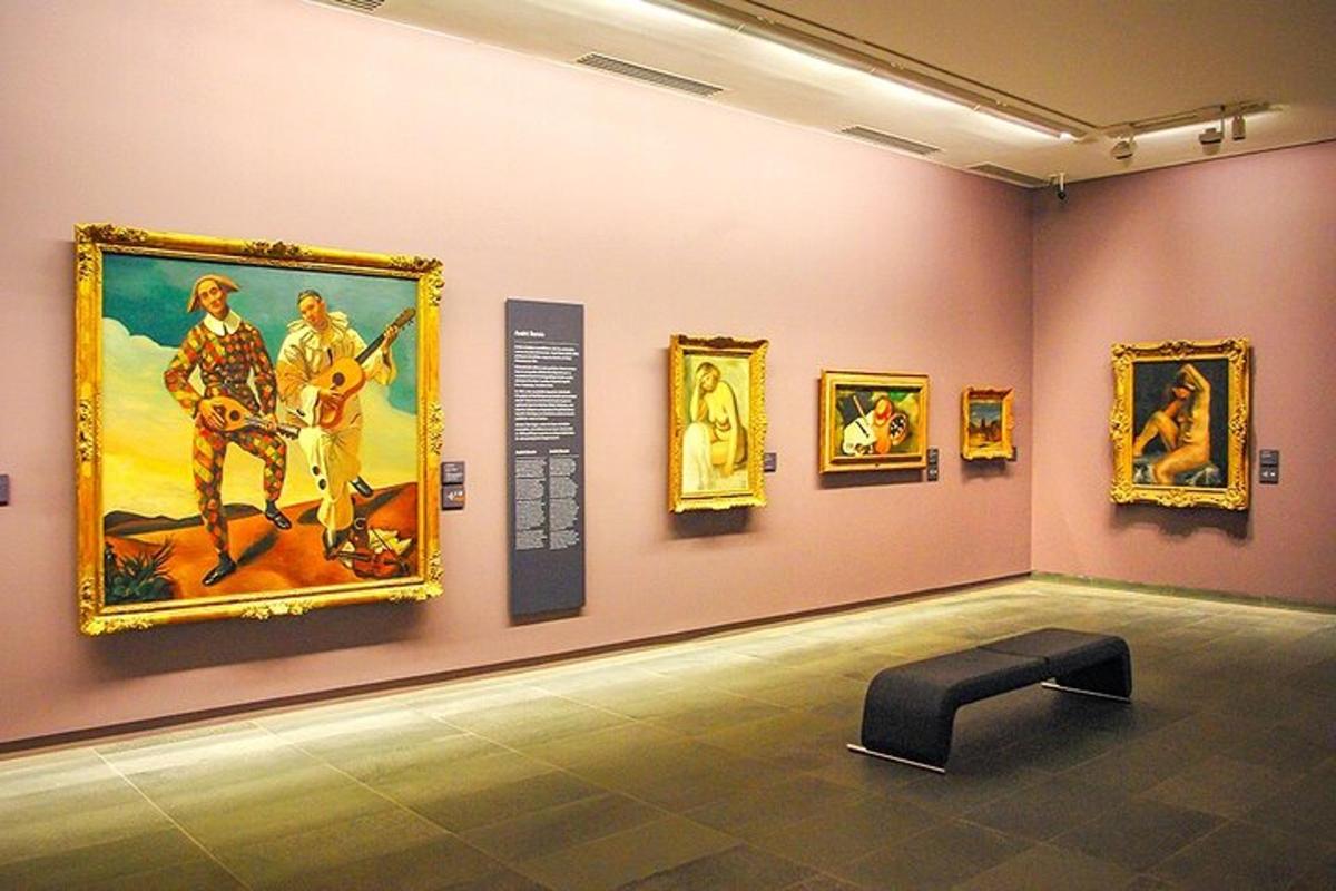 muzejní expozice s obrazy na zdi a lavičkou