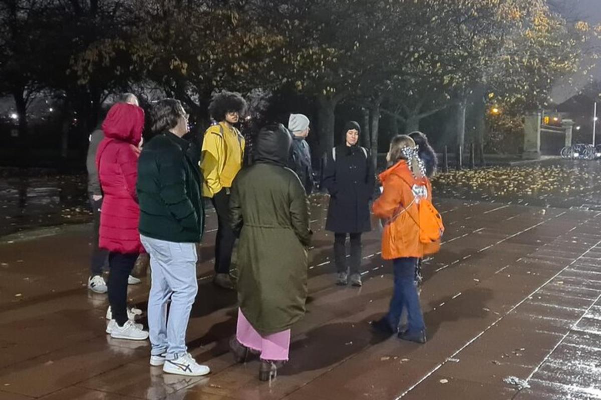 μια ομάδα ανθρώπων που περπατούν σε έναν δρόμο τη νύχτα