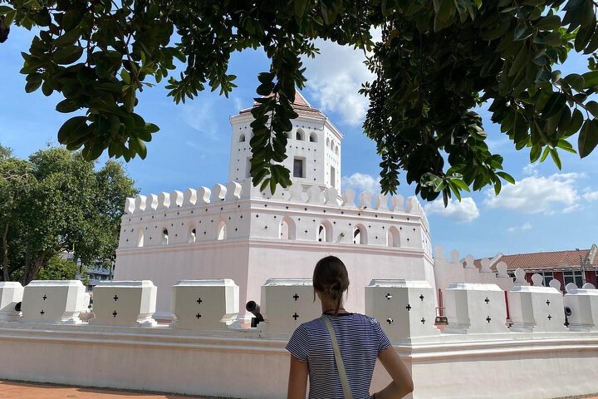 osoba sedící na zdi před budovou
