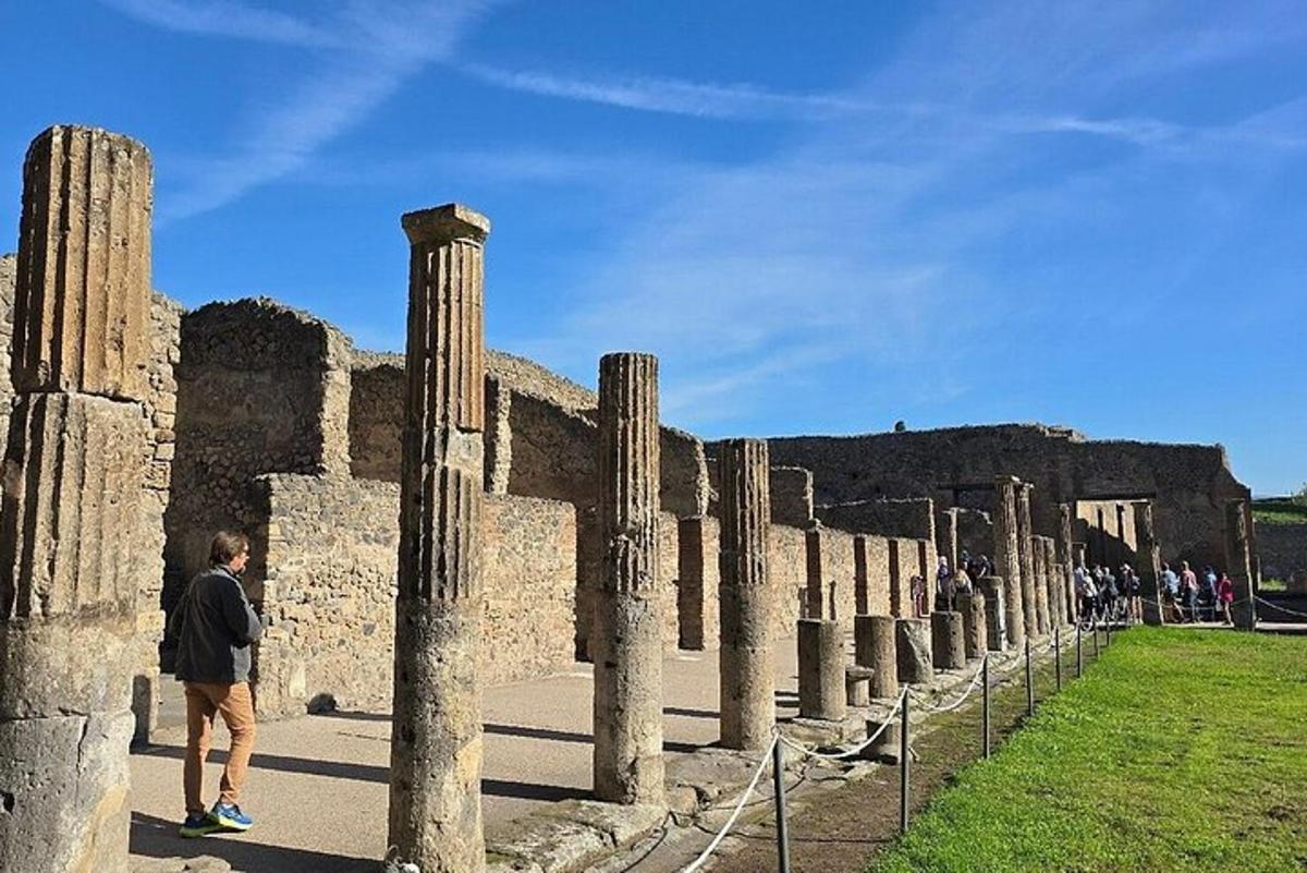 una persona in piedi davanti a un edificio con colonne