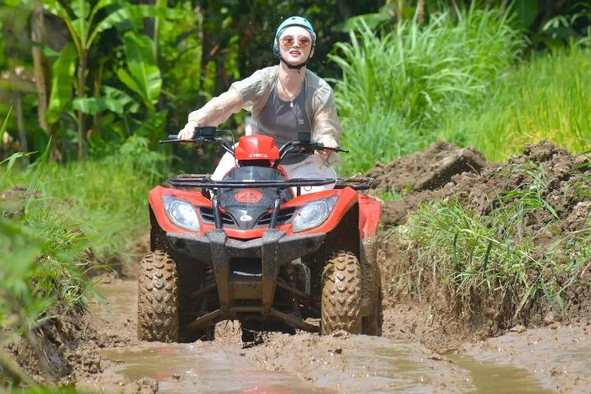 seorang lelaki menunggang kenderaan empat roda melalui kawasan balak lumpur