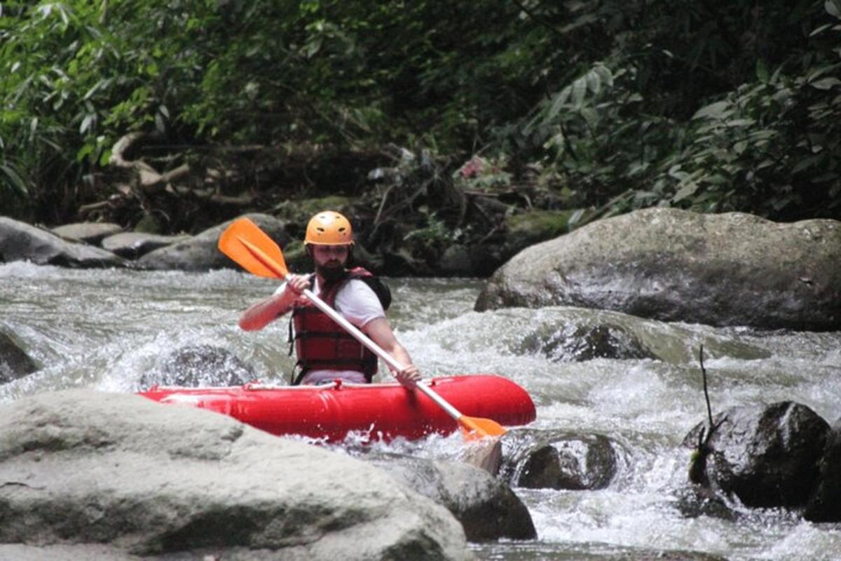 una persona su un kayak rosso in un fiume