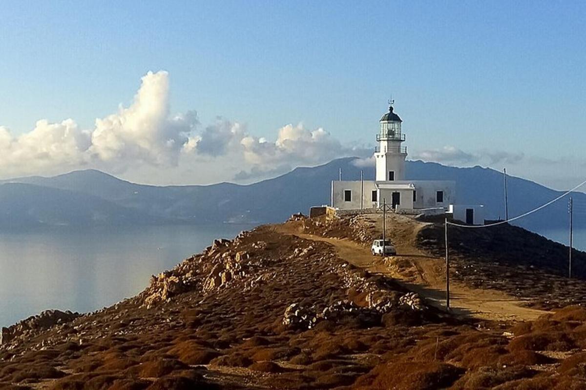 um farol no topo de uma colina perto da água