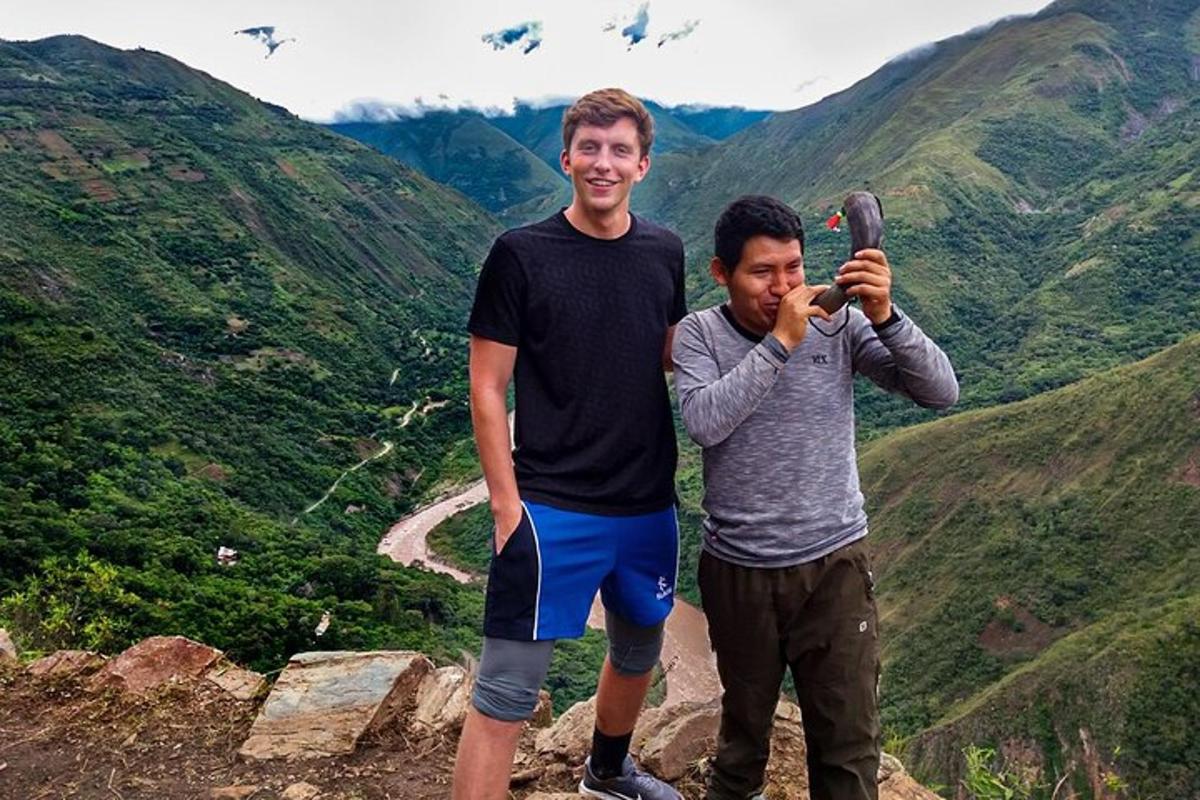 dois homens em pé em uma montanha tirando uma foto