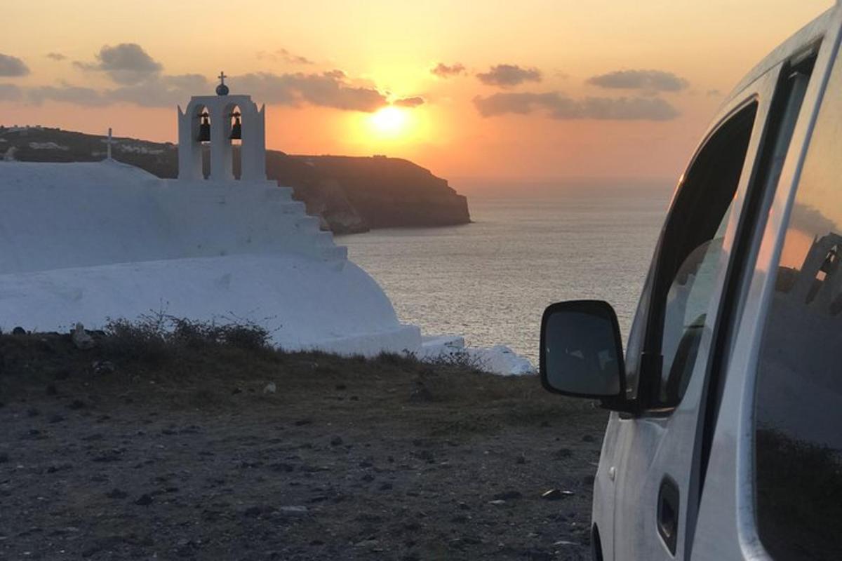 a van parked next to the ocean with the sunset