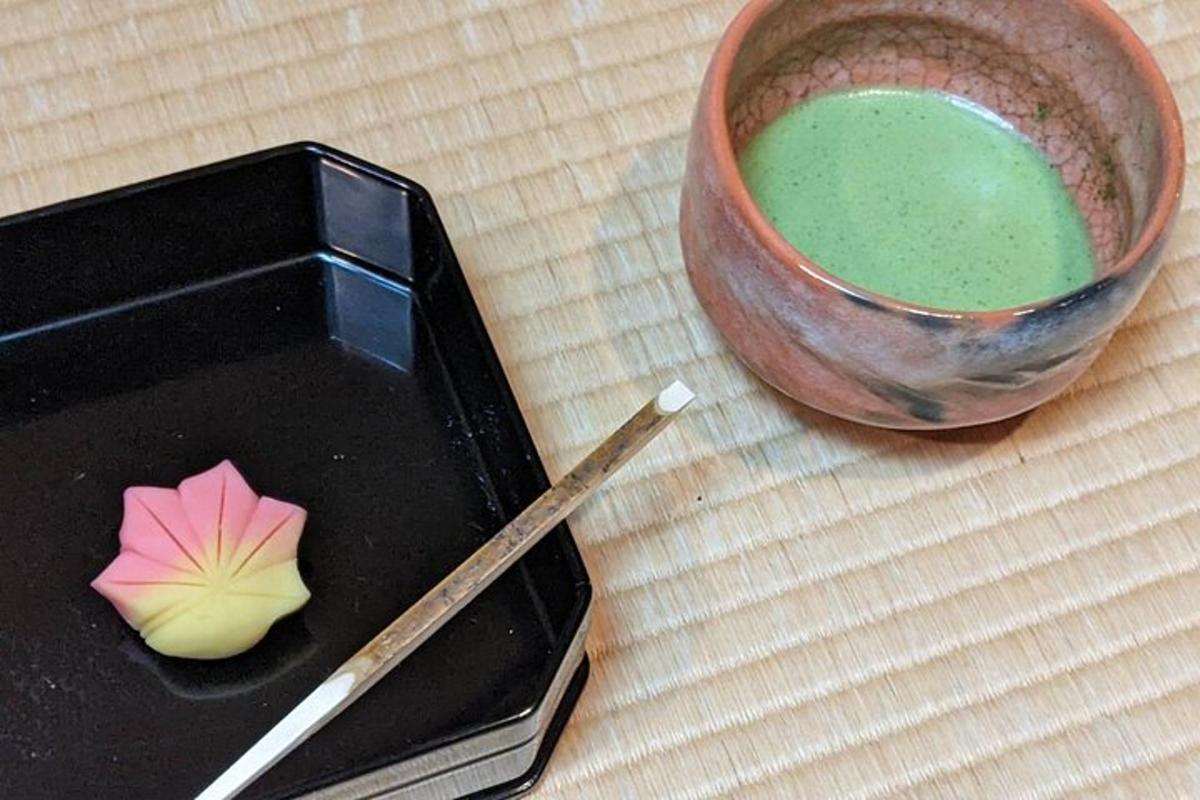 a bowl of green liquid next to a wooden chopstick