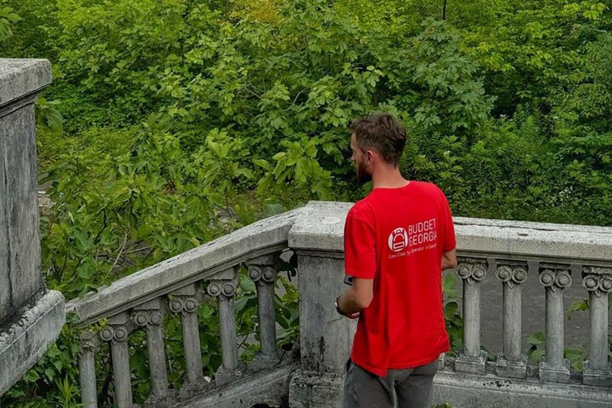 a man in a red shirt standing on a railing