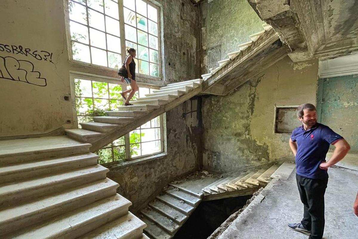 a man standing on the stairs of an abandoned building