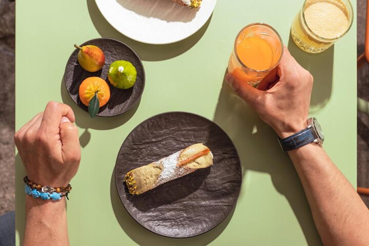 un tavolo con piatti di cibo e una persona che tiene in mano una bevanda