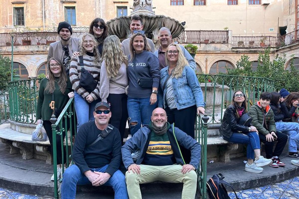 un gruppo di persone in posa davanti a una statua