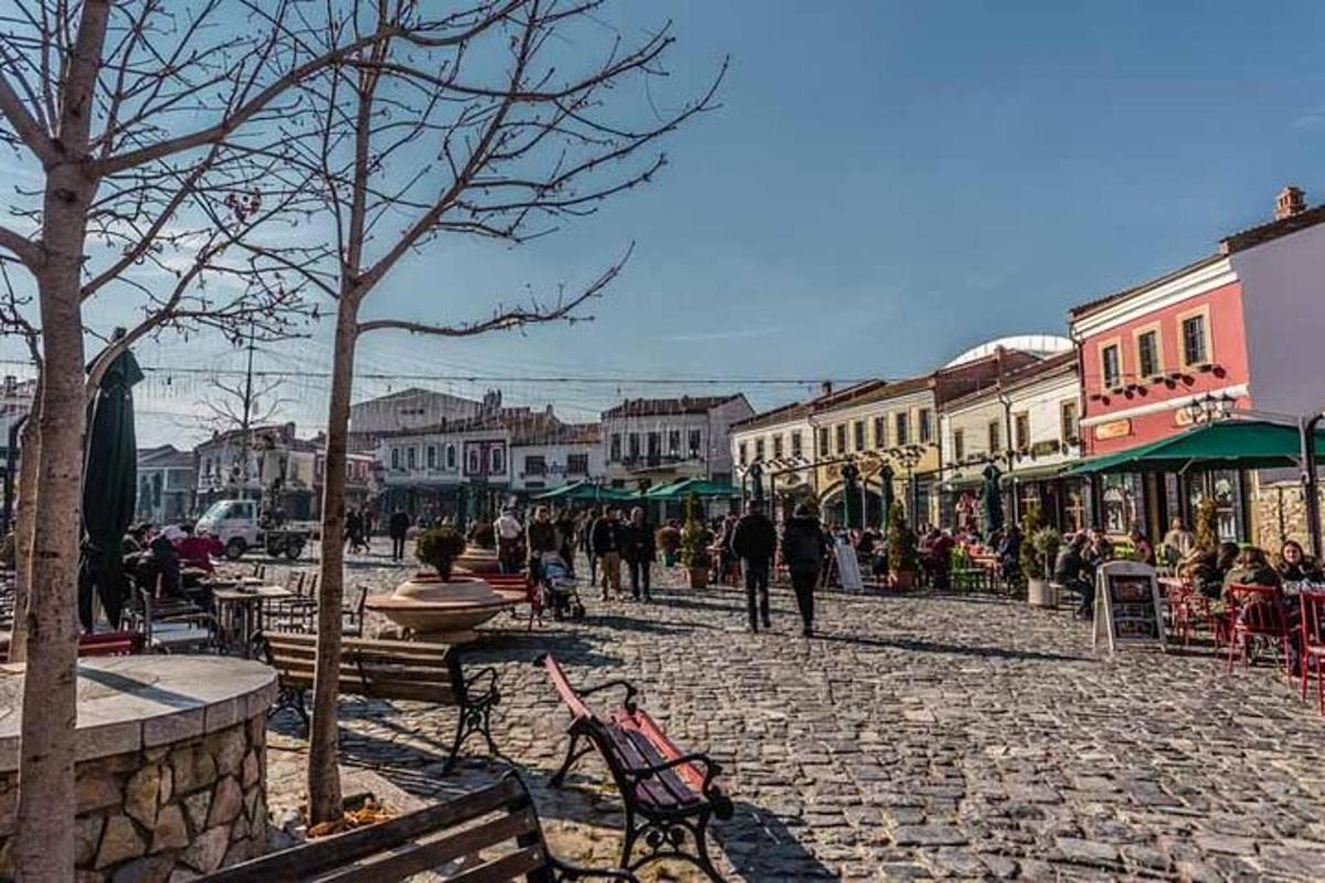 un carrer empedrat en un poble amb gent passejant