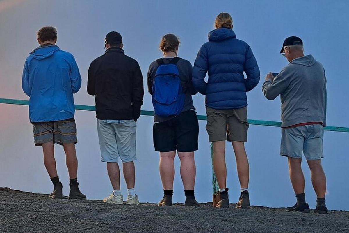 a group of people standing next to a fence