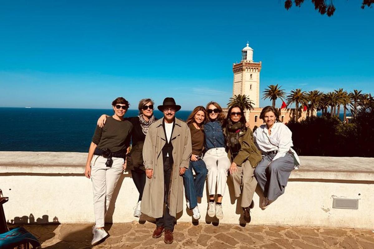 Un grupo de personas posando para una foto frente a un faro.