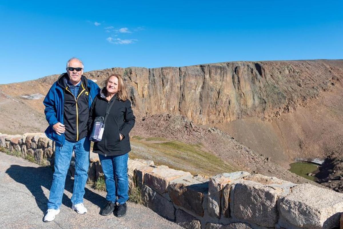a man and woman standing on top of a cliff