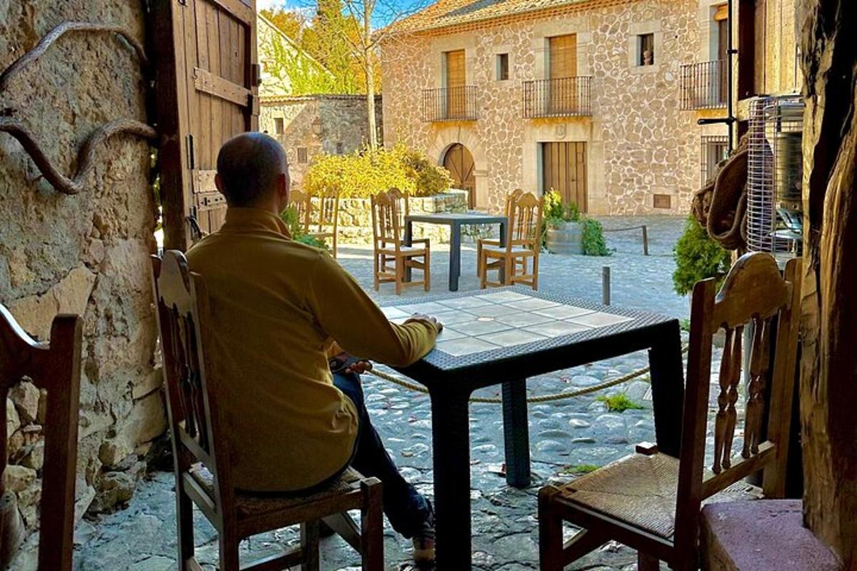 moški, ki sedi za mizo na terasi