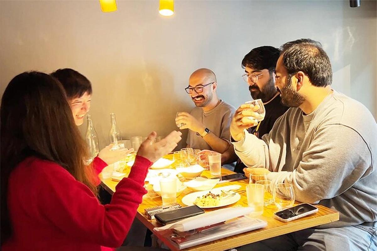 grupp inimesi, kes istuvad laua ümber ja söövad toitu