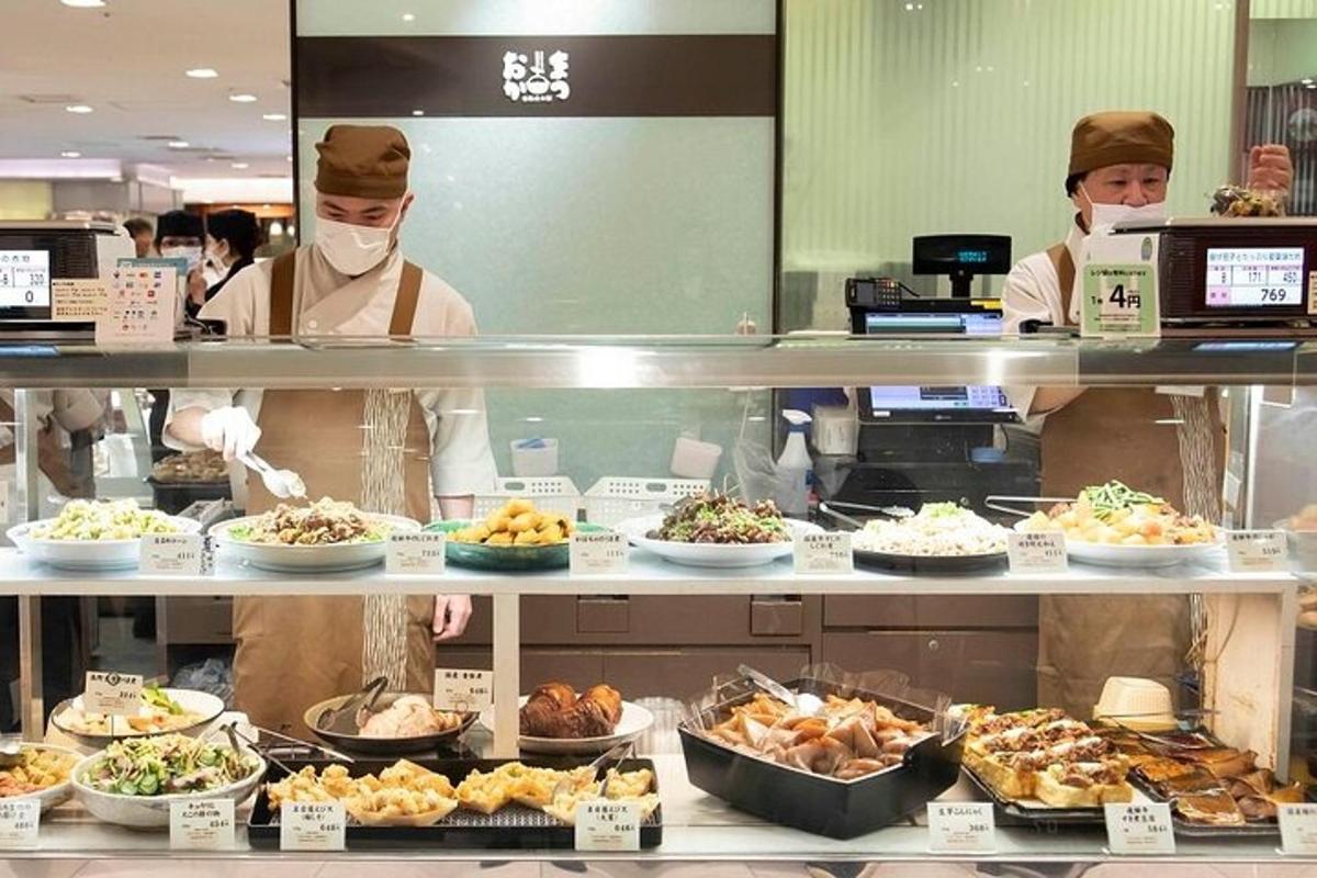 dua tukang masak menyediakan makanan di dapur restoran