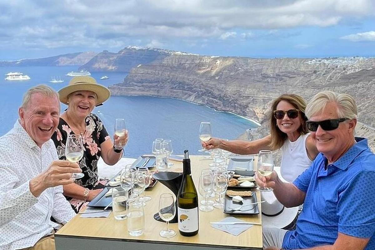 skupina ljudi, ki sedijo za mizo z vinskimi kozarci