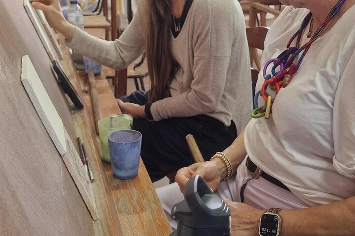 Dos personas sentadas junto a una mesa con una taza.