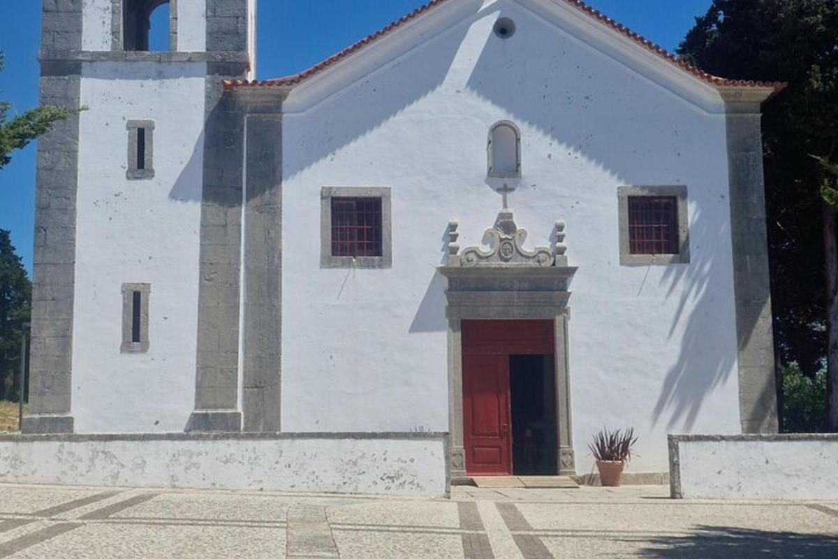 una petita església blanca amb una porta vermella