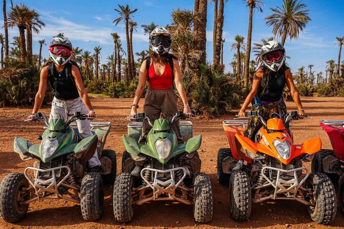 three people are standing on atvs in the dirt
