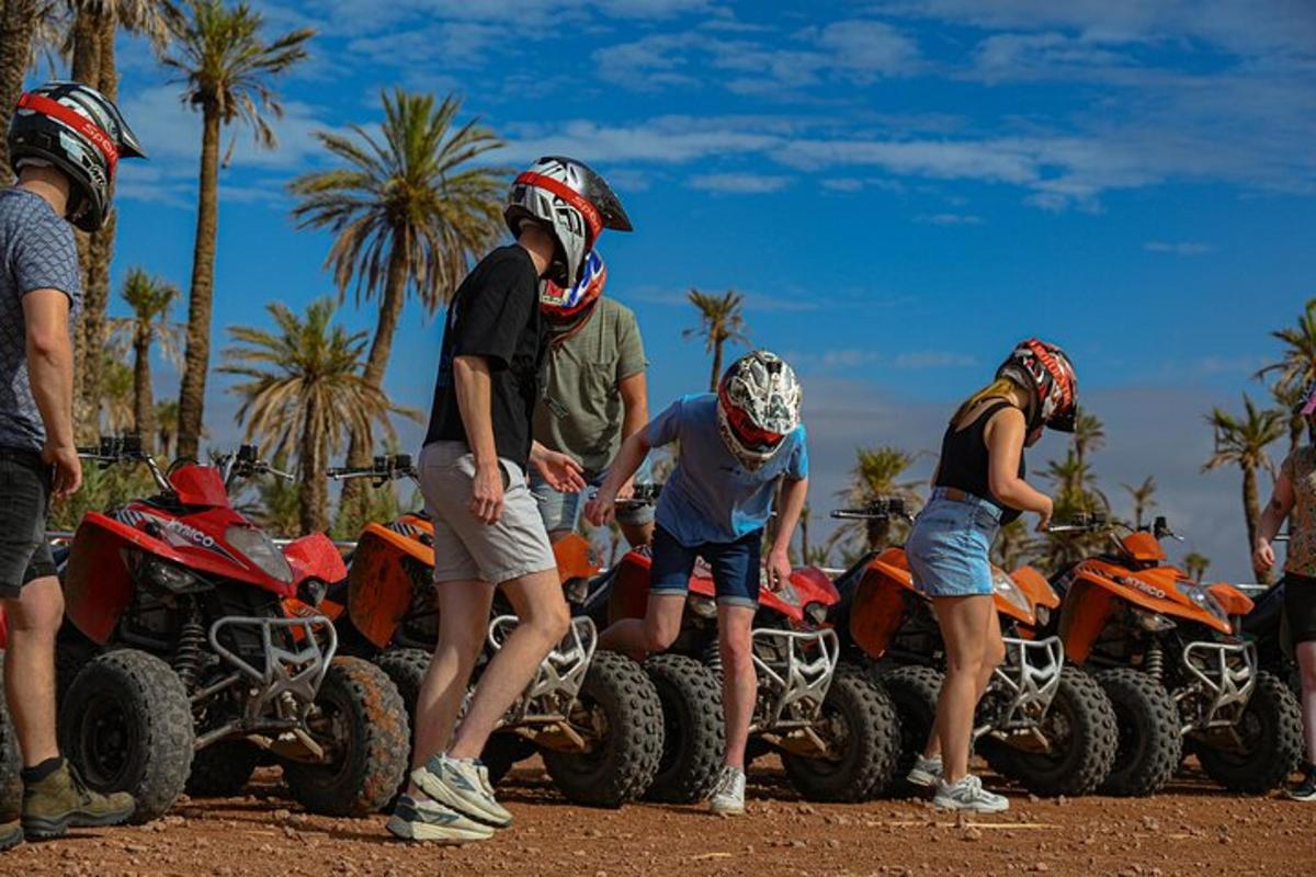 a group of people standing around atvs in the dirt