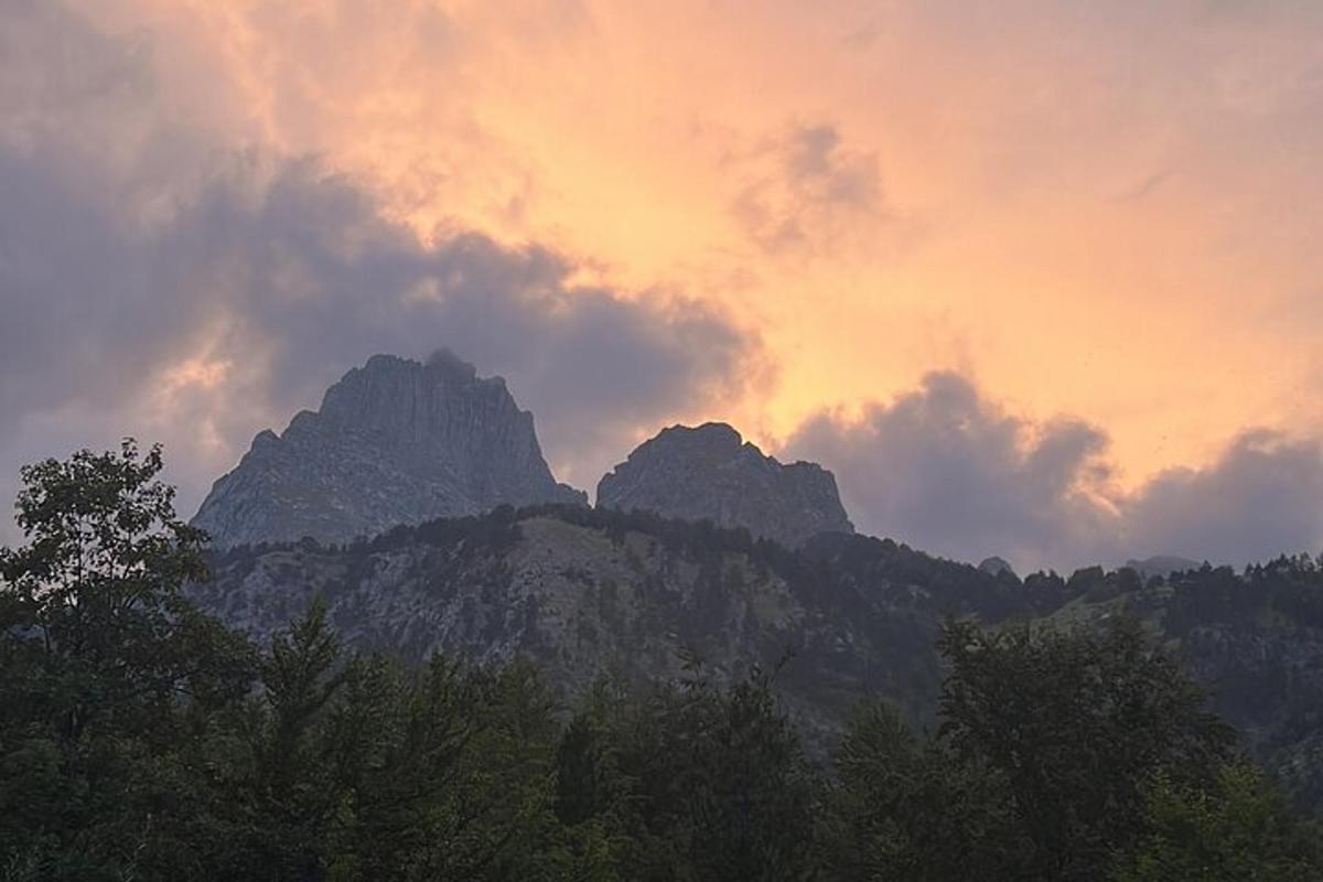 sekumpulan gunung dengan latar belakang matahari terbenam