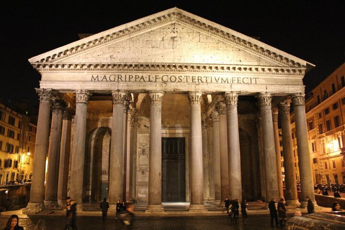 a large building with columns in a city at night