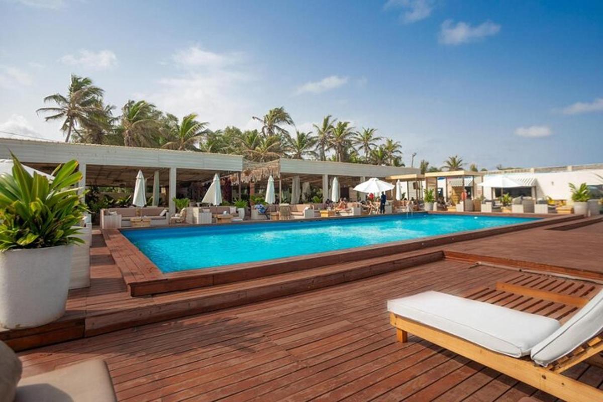 a swimming pool on a wooden deck next to a resort