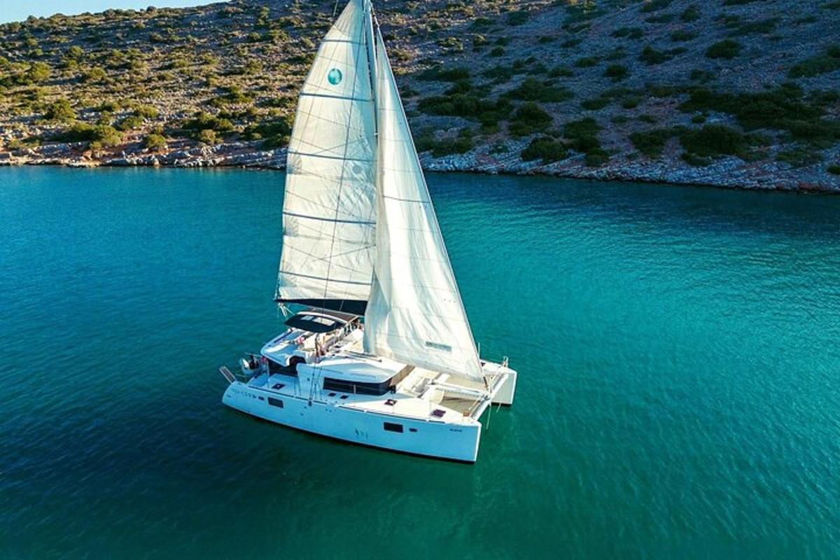 una barca a vela bianca su uno specchio d'acqua
