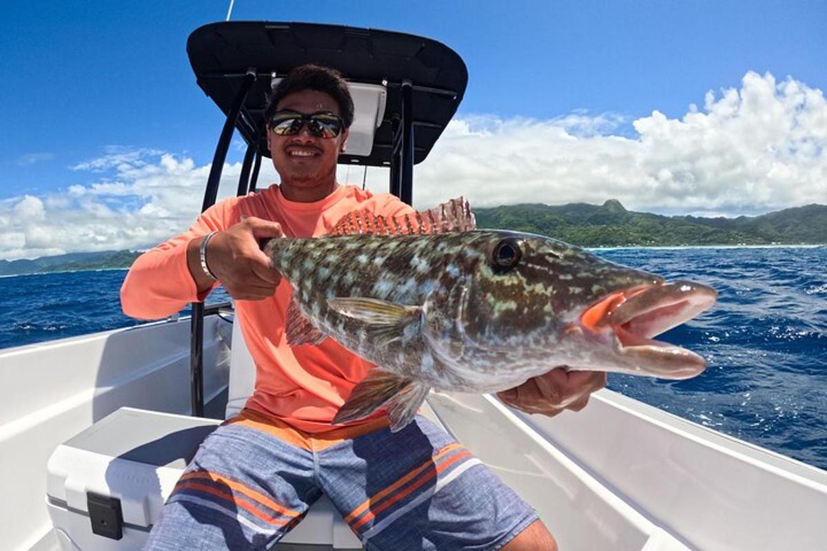 a man holding a large fish in a boat
