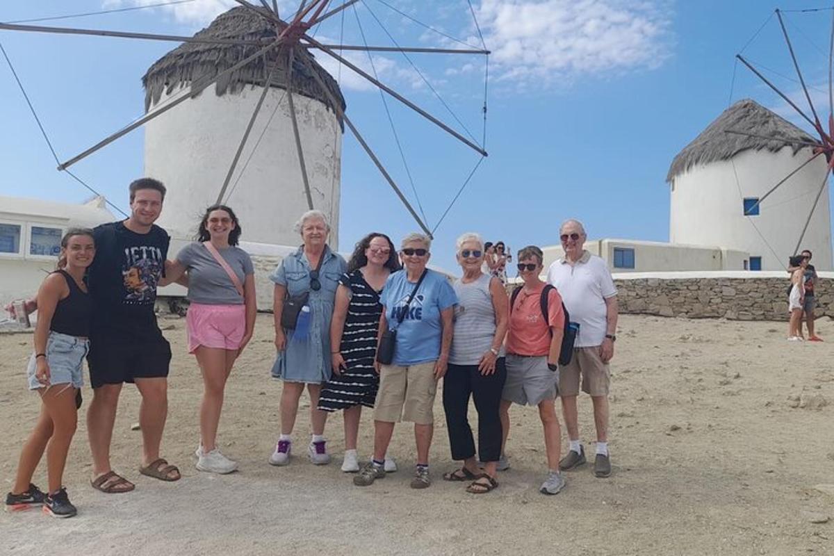 un gruppo di persone in piedi davanti a un mulino a vento