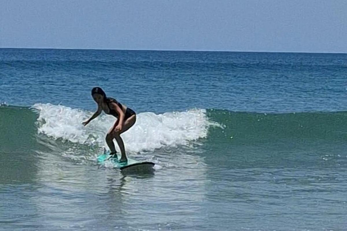 o femeie călărind un val pe o placă de surf în ocean