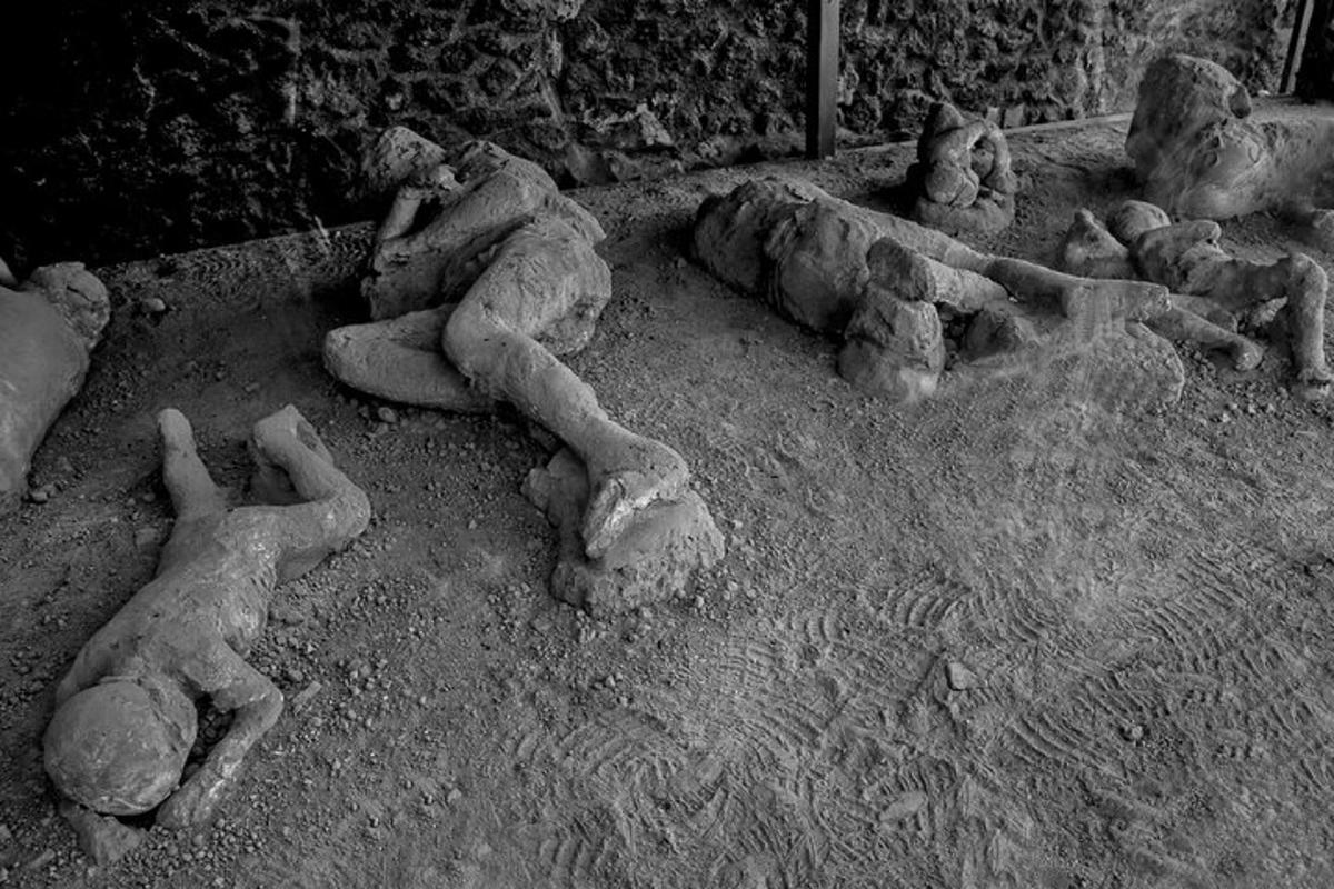 un gruppo di statue di persone sdraiate sulla sabbia