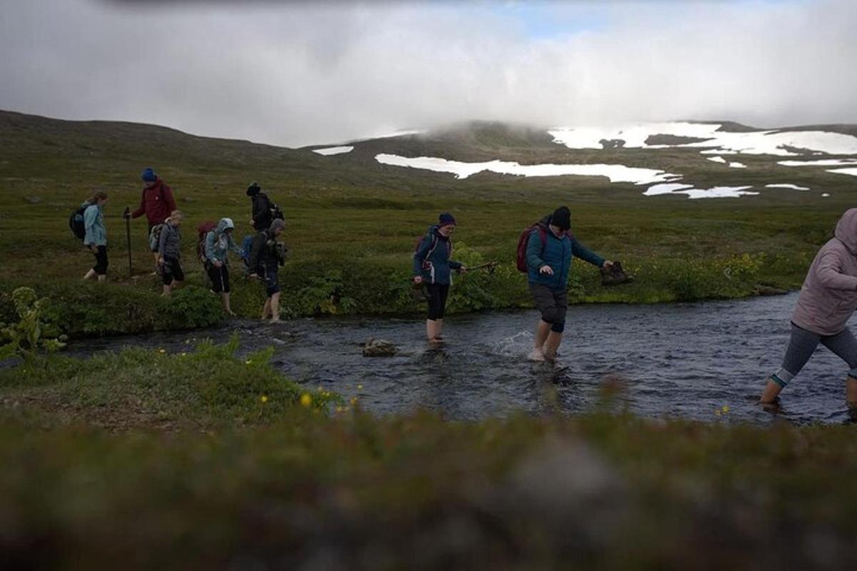 a group of people walking across a stream