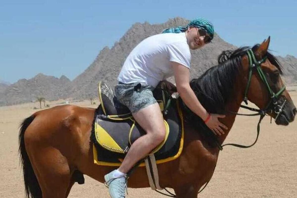 um homem cavalgando um cavalo no deserto