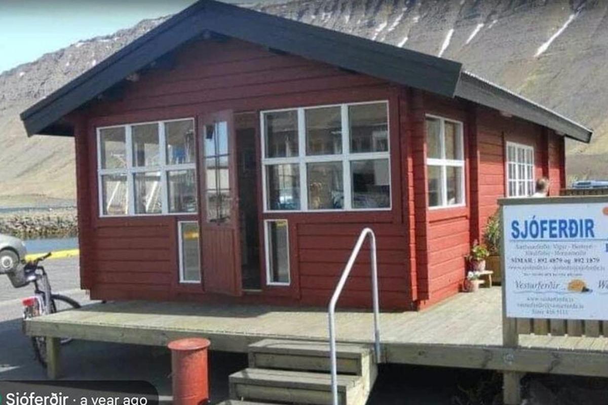 ett litet rött hus på en brygga med en skylt