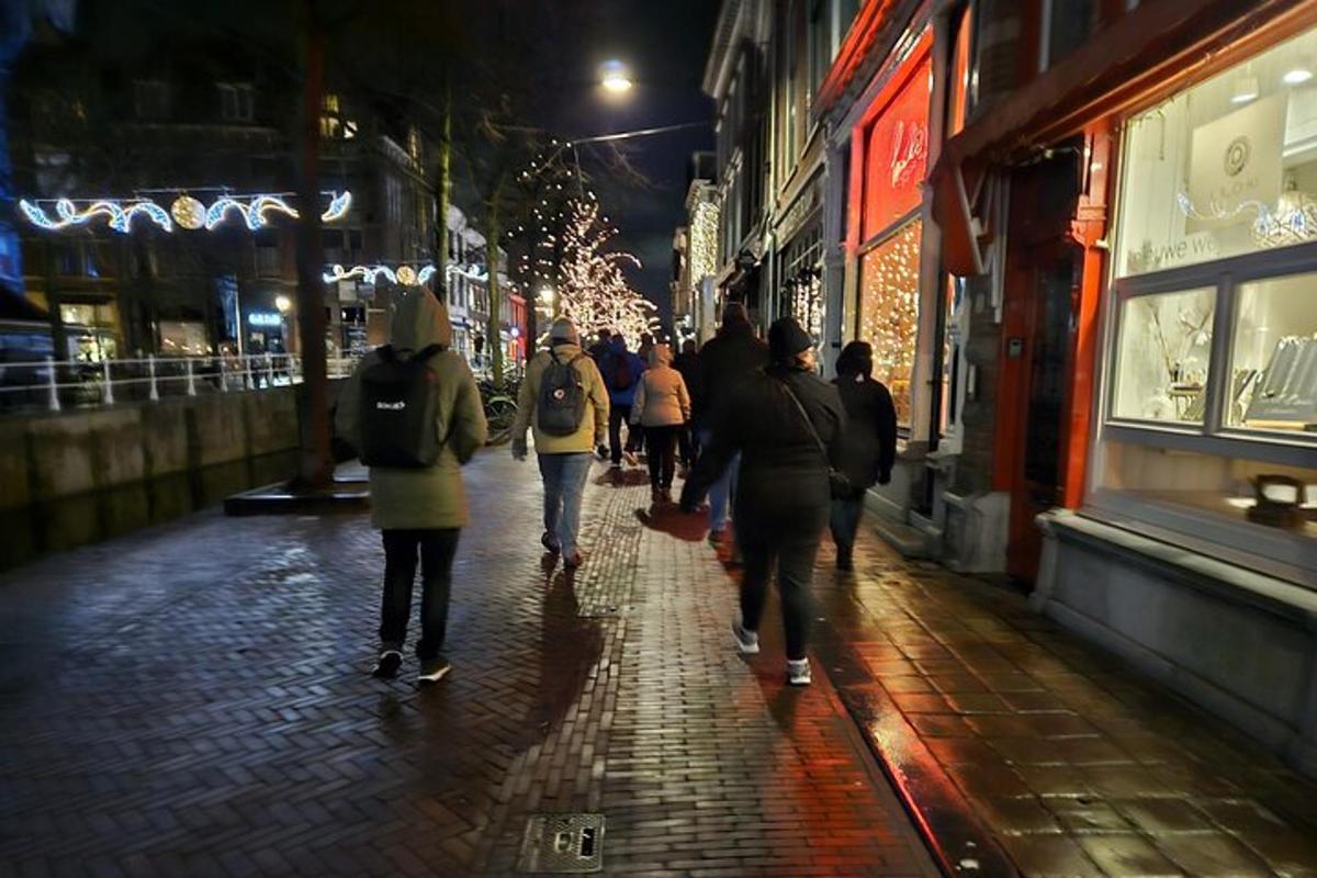 un gruppo di persone che camminano lungo una strada di notte