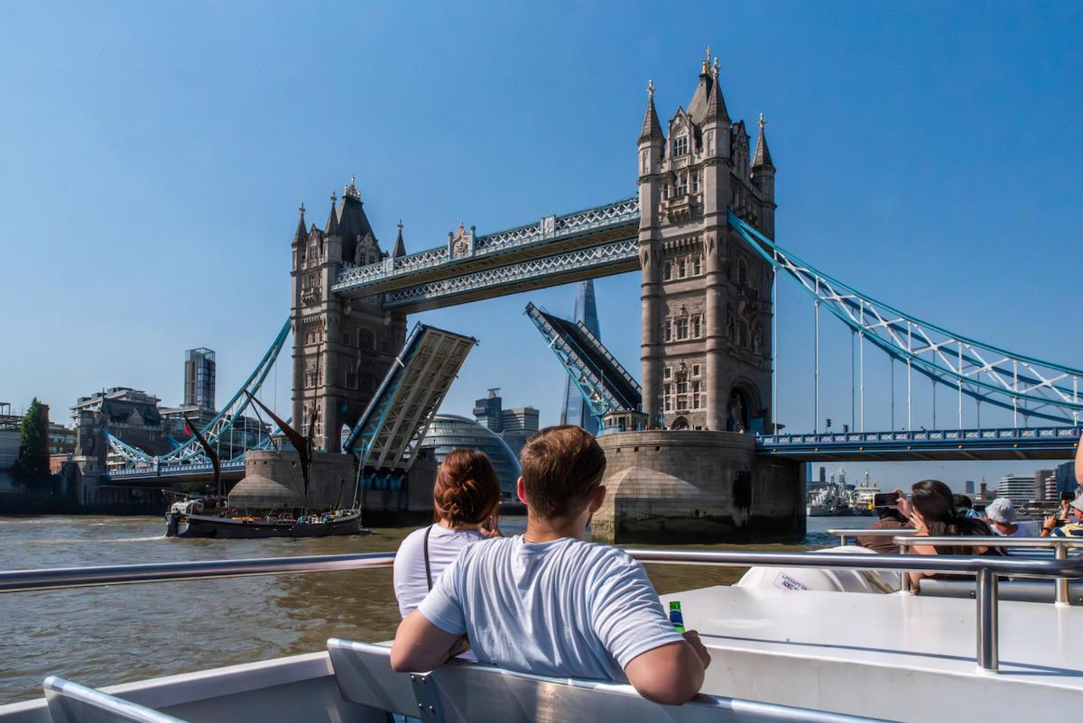 two people on a boat in front of the tower bridge