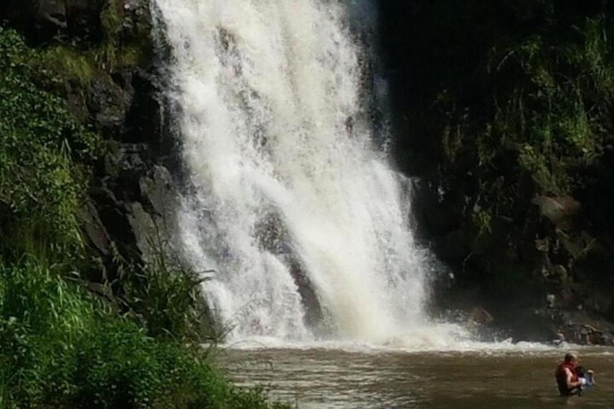 una persona in piedi nell'acqua di fronte a una cascata