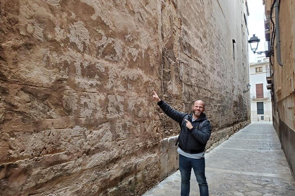 Un hombre está de pie junto a una pared