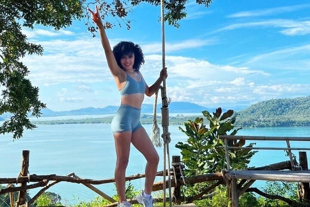 Una mujer en bikini parada en un columpio de cuerda