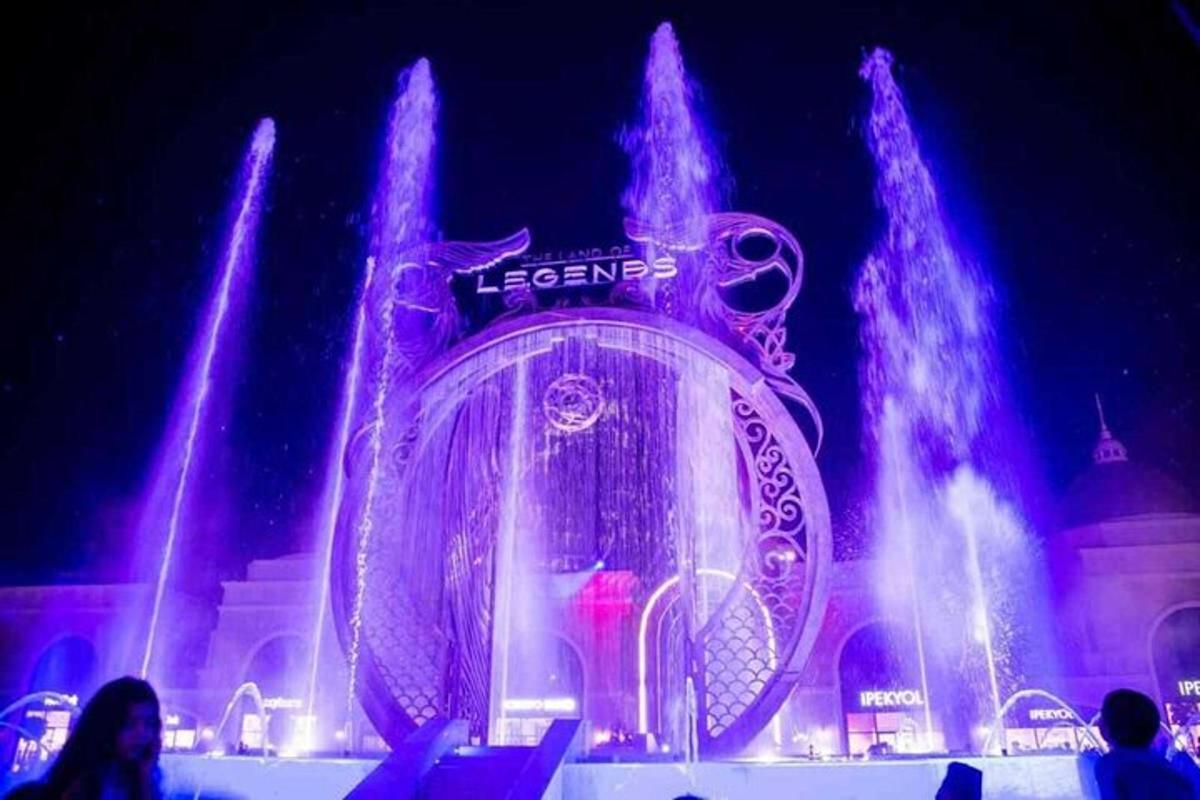 a fountain in front of a building with purple lights